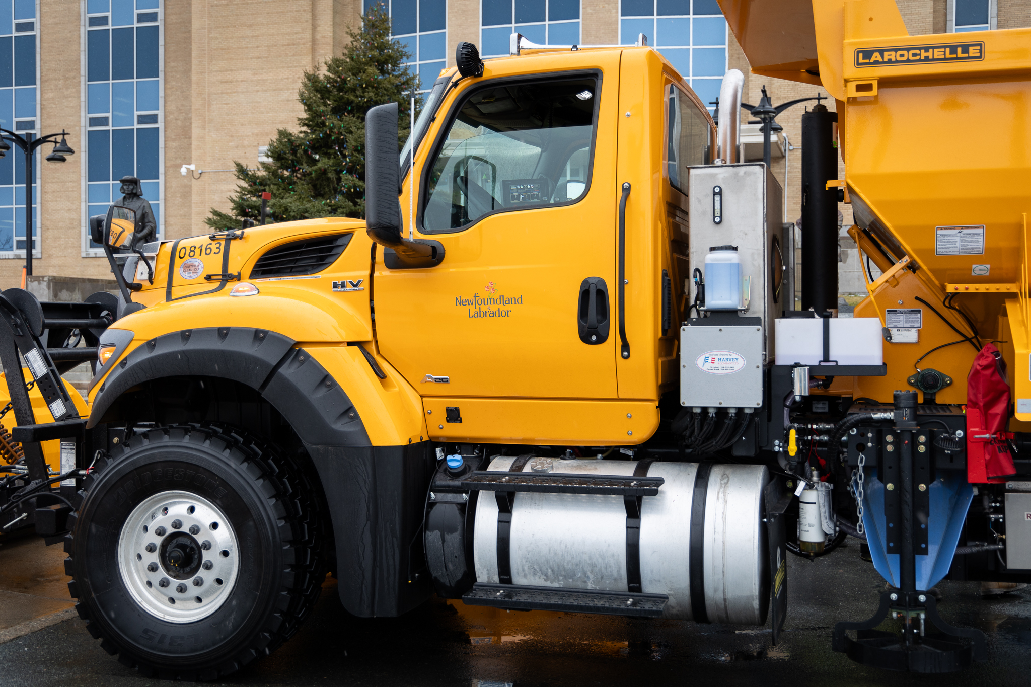 a yellow snow clearing truck parked in front of Confederation Building.